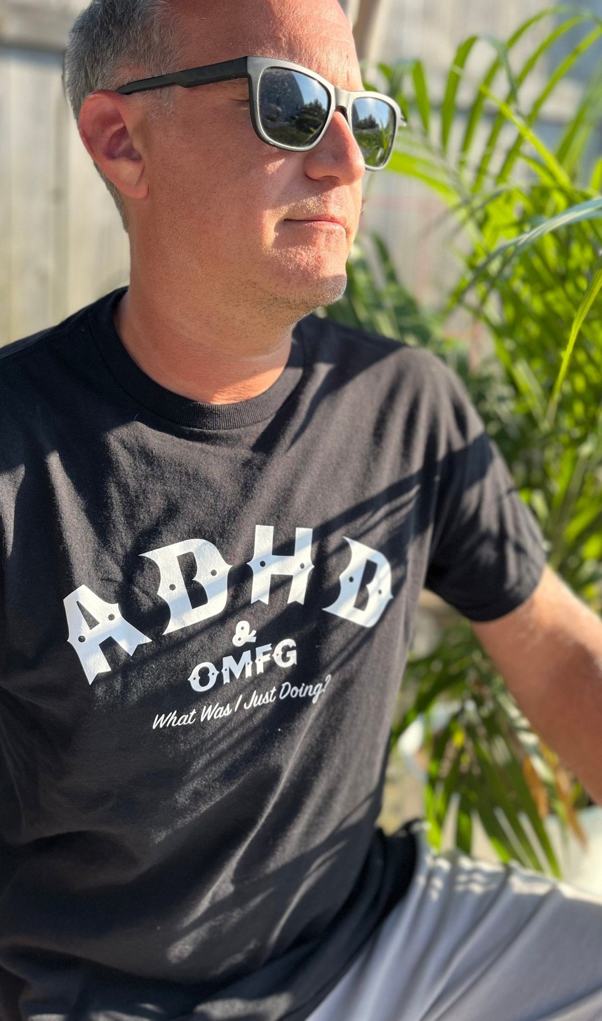 Man wearing a black t-shirt with the text 'ADHD & OMFG What Was I Just Doing?'